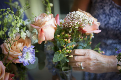 Woman's hands holding a small bouquet with pink roses