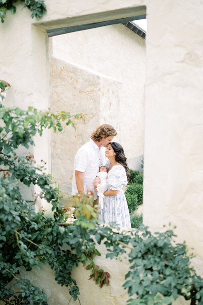 a beautiful family stands in an outdoor setting during their San Antonio Newborn Photo session