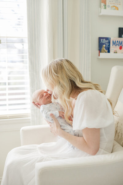 Portrait of mother kissing her newborn baby's cheek-Newborn Photography Greenville SC