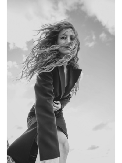 woman on a beach in a dress holding up her hair