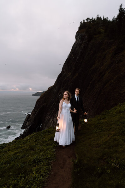 Couple walking with lanterns at dusk on the Oregon Coat.