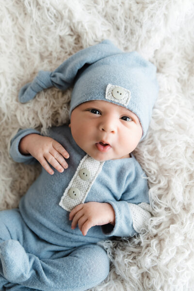 baby boy in blue romper and hat awake and looking cute  Baby Photography Pittsburgh PA