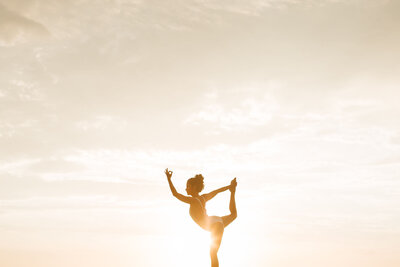 Femme en position de yoga sur coucher de soleil