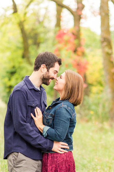 Engaged couple holding hands and laughing in black and white