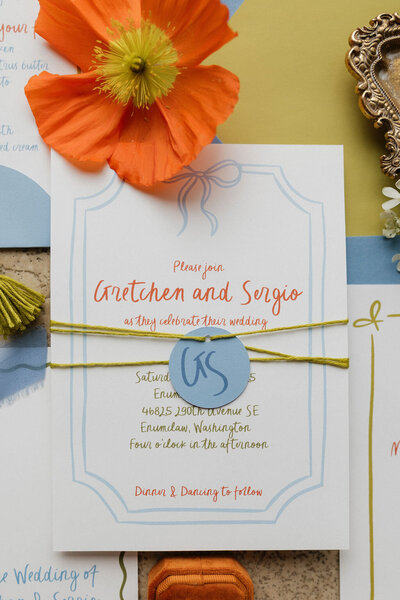 Editorial citrus wedding invitation suite flatlay with layered stationery