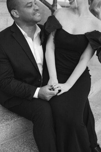 woman sitting on man lap holding hands