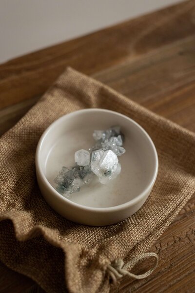Crystal in a small white dish on top of a burlap bag