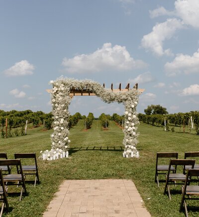 Arbor covered in flowers for an outdoor  wedding ceremony
