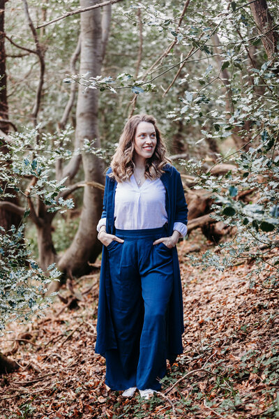 Kate is standing with her hands in her pockets