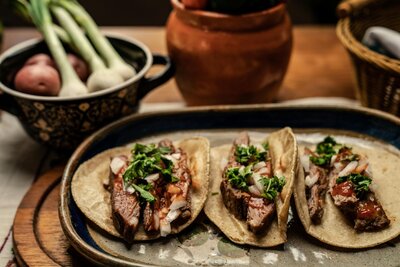 Tender steak tacos topped with fresh cilantro, onions, and a tangy salsa, wrapped in warm tortillas for a savory Tex-Mex treat.