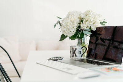 Laptop next to a bouquet of flowers