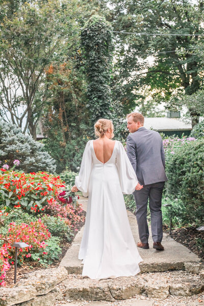 bride and groom walking through a garden for wedding portraits