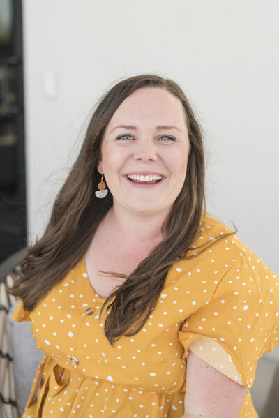 a woman smiling in a yellow dress