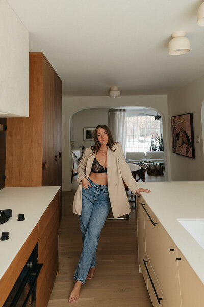 woman in lingerie and a blazer leaning on counter