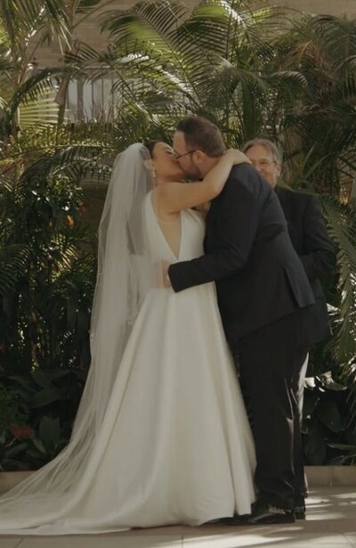 bride and groom kissing at altar