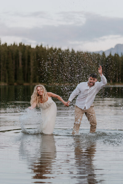 Married couple splashing water at each other at Two Jack Lake