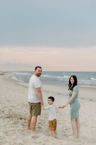A family poses on the beach for their sunset portrait session