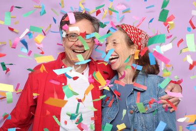 Smiling couple enjoying a vibrant photo booth experience with colorful confetti at an MISGIF Arizona corporate event. Perfect for team-building, brand activations, and corporate celebrations. Book a premium photo booth package today!
