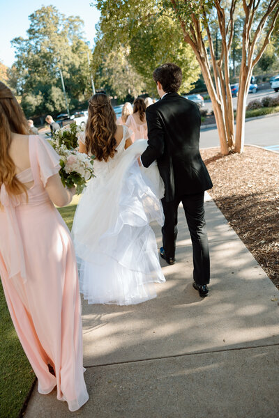 Bride holds bouquet and looks at the groom as they go in for a kiss.