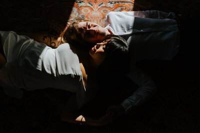 couple laying down on ground face to face