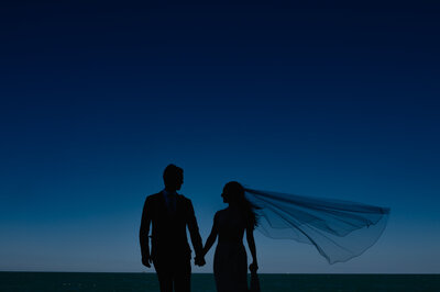 Bride and groom hold hands in front of an I love you mural  in Chicago