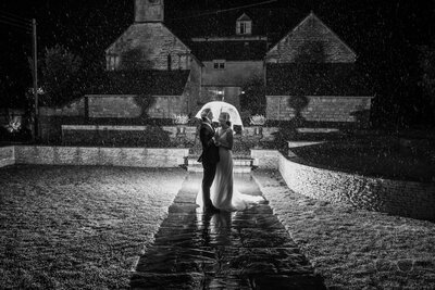 Bride and Groom laughing and standing in the rain