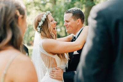 Bride and Groom hold each other and laugh. Photo by Anna Brace who specializes in Omaha Wedding Photography.