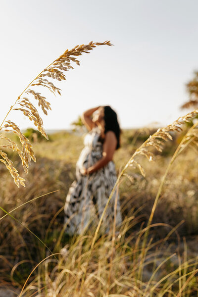 gainesville fl maternity photo mom holding baby bump next to beach