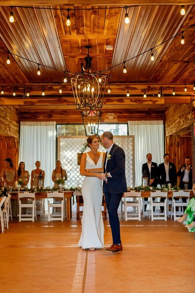 Married couple dancing in front of their wedding party