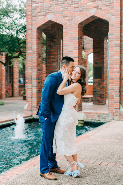 Groom kissing bride on cheek during engagement session.