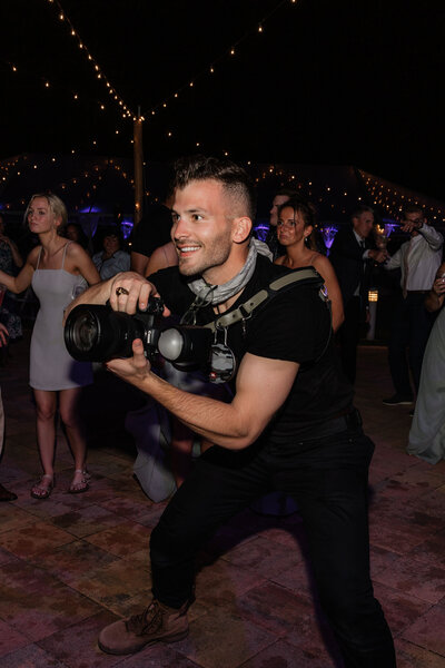 Will holding his camera to shoot on a wedding dance floor