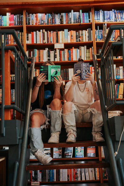 KP and Jessie read books on a step.