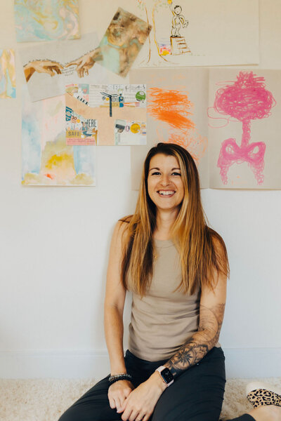 person sitting in front of a wall of hand drawn art