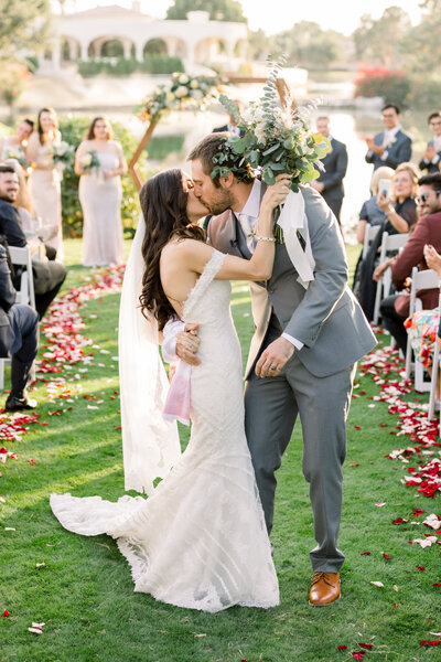 Bride and Groom Walking down the aisle and kissing on their wedding day in Arizona.