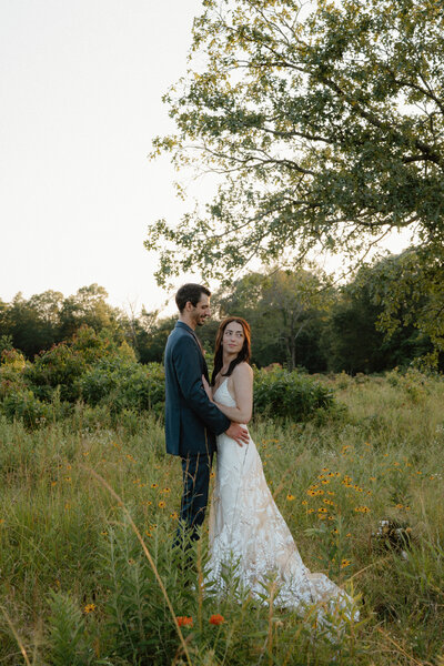 romantic elopement photo of a bride and groom holding each other in a field of flowers