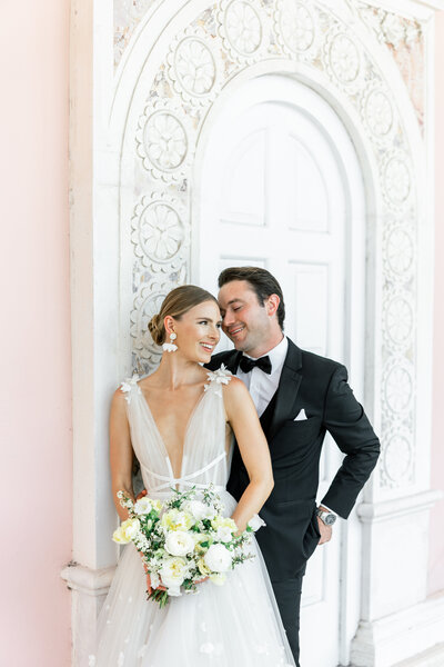 bride and groom leaning on each other and on wall by sarasota wedding photographer