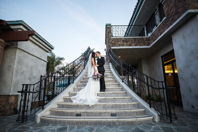Bride and Groom share a kiss on the steps of an outdoor staircase