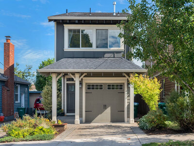 The front of a blue house with a garage.