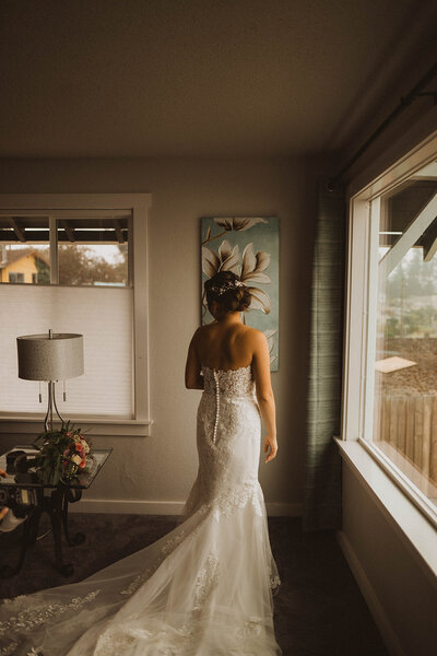 seattle bride turns back to look at her flowers as she waits for her seattle elopement ceremony to begin