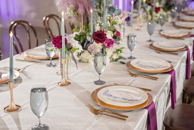 Luxury wedding reception table featuring gold-rimmed plates and floral decor for an elegant event.