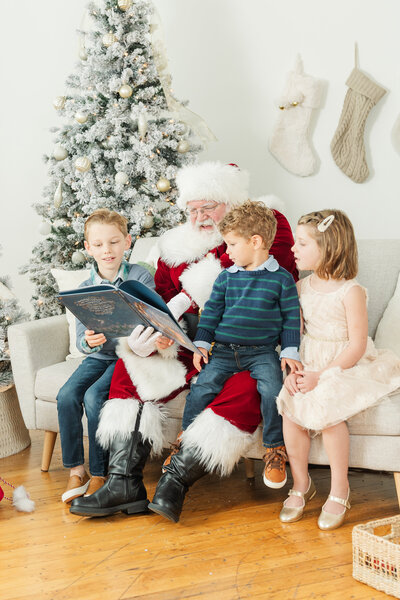 siblings sitting in an outdoor setting, the older sister kisses the younger sister on the forehead