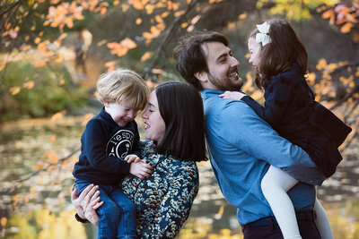 Two parents each holding a small child