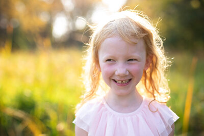 Girl smiling at the Minnehaha Creek for family photographers in Minneapolis, MN