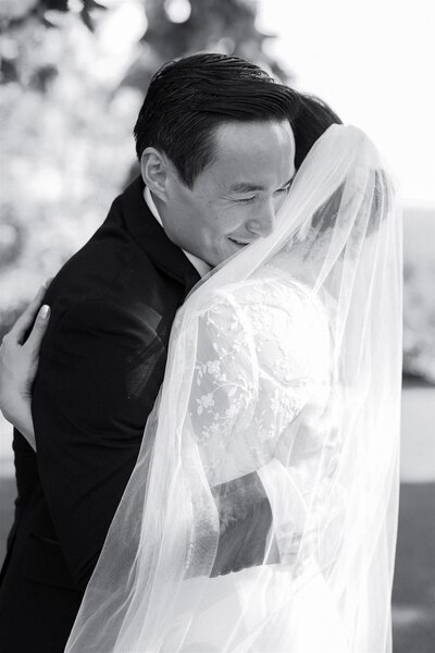 A wedding couple hugging and smiling 