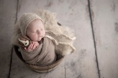 Newborn with puppy sleeping  in bucket in Plymouth Indiana Newborn Photography Studio