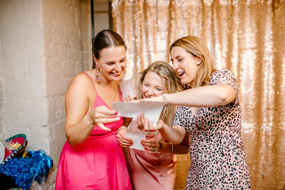 guests looking at their instant prints  image of guests having the best time during a photo booth picture