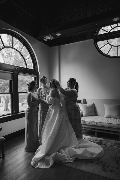 Bride and groom sit on a clawfoot bathtub