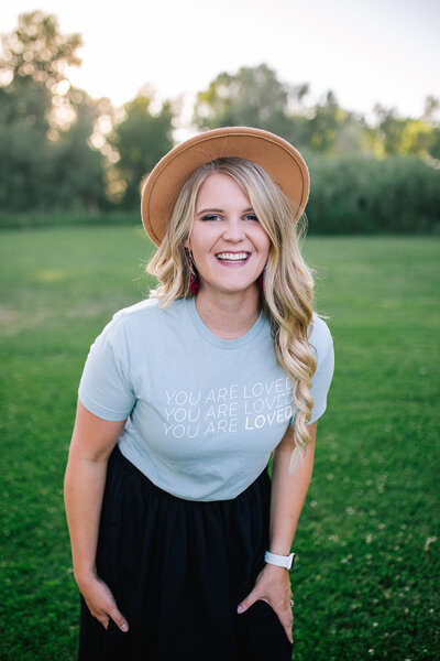 Idaho based wedding photographer smiling at the camera  while wearing a brown wide rimmed hat