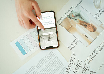 Web designer Haylee Harris of Bostron Design Studio scrolling through a custom website she designed and built on her phone.