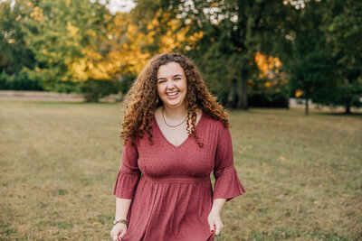 senior photographer in madison al by whitney briscoe - high school senior girl smiling at camera in a field in the fall